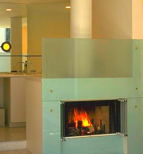 A fireplace in the corner of a room with a yellow light.