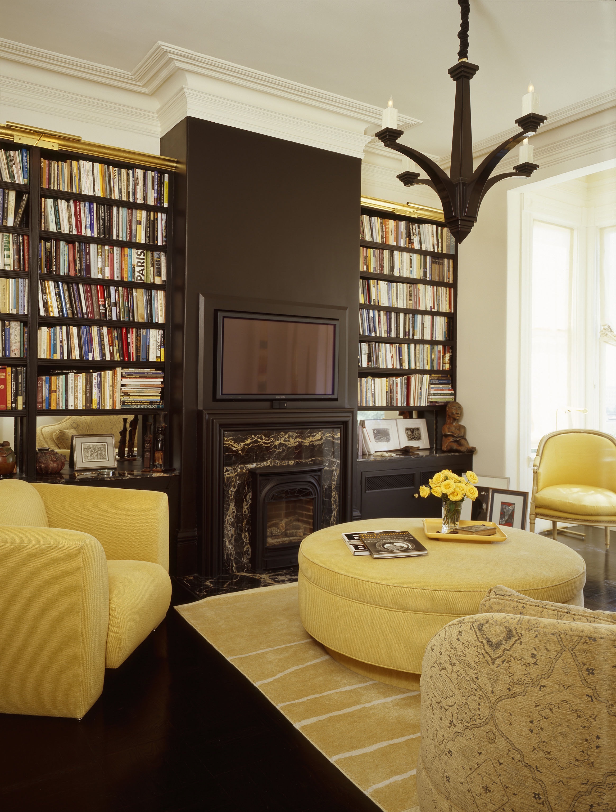 A living room with yellow furniture and a fireplace.